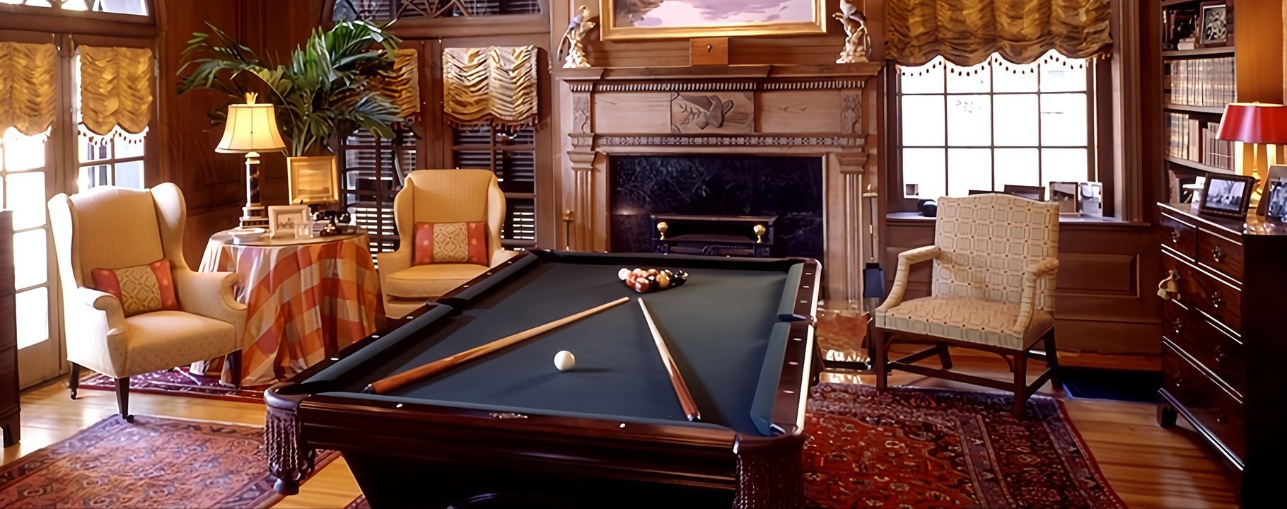 A pool table in the middle of a room with a fireplace.