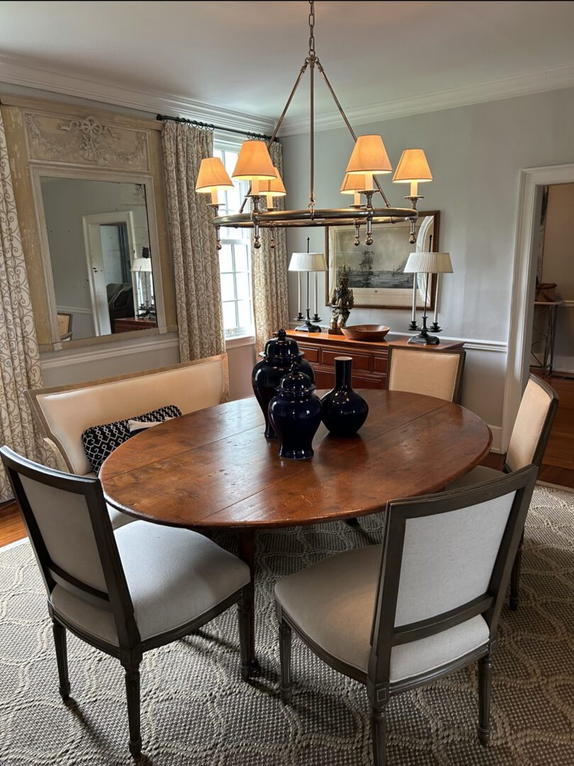 A dining room table with six chairs and a chandelier.