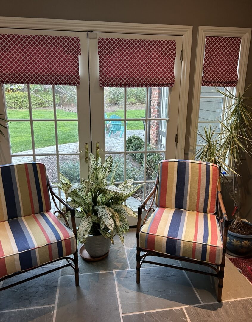 Two chairs with colorful cushions in a room.