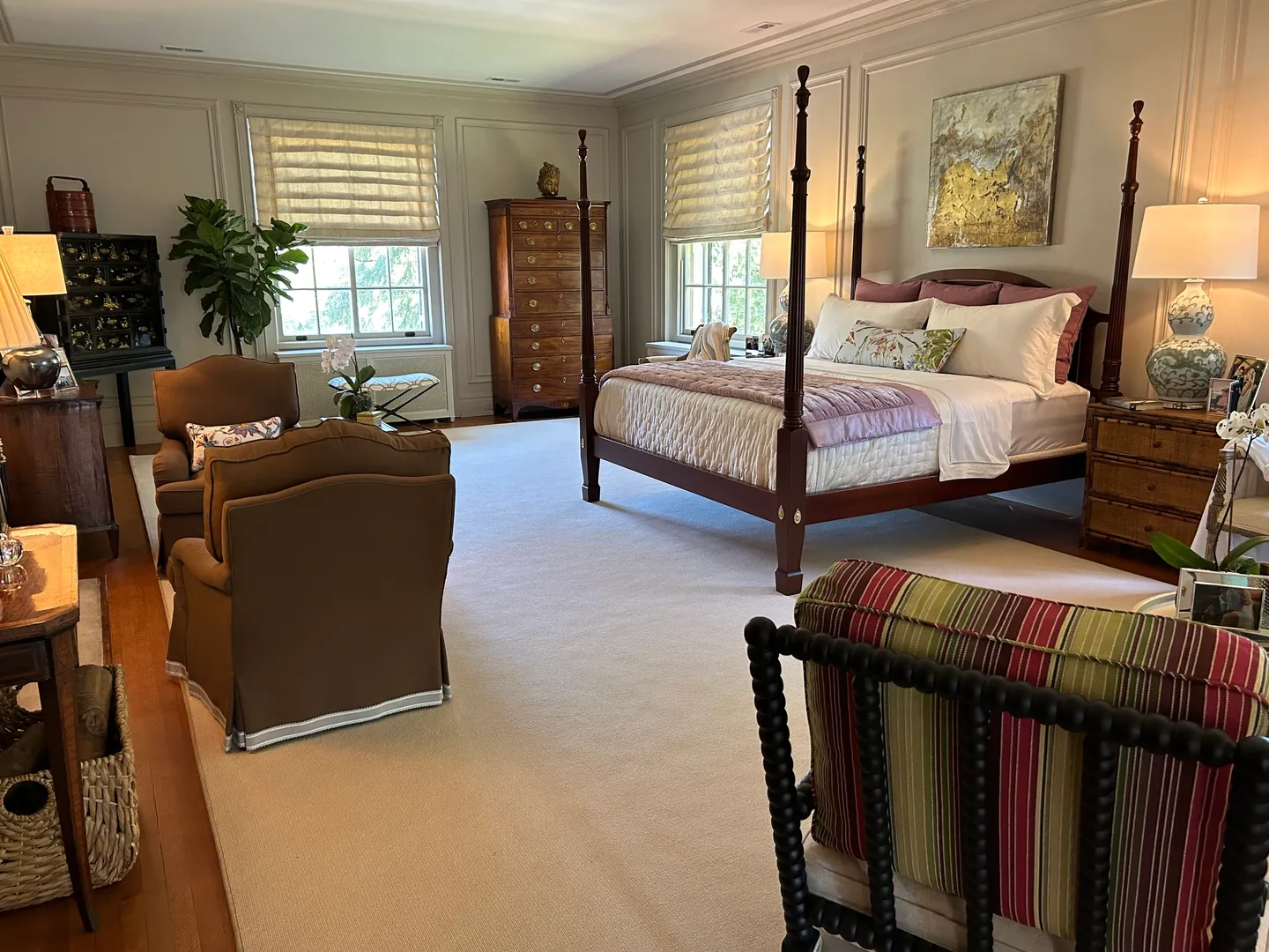 A large bedroom with a bed, chair and dresser.