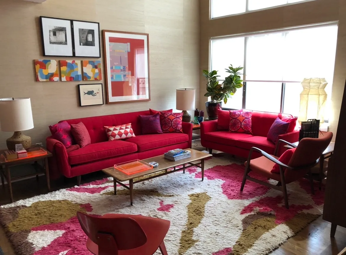 A living room with red couches and a coffee table